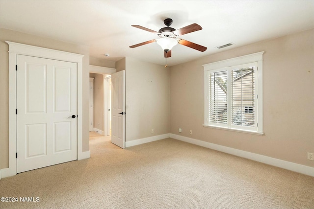 unfurnished room featuring ceiling fan and light colored carpet