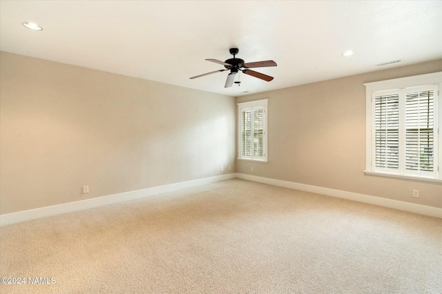 carpeted spare room featuring ceiling fan