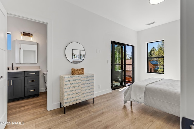 302 W Oak Ave Unit 5, Flagstaff, AZ 86001 - bedroom with access to outside, a sink, light wood finished floors, baseboards, and ensuite bath