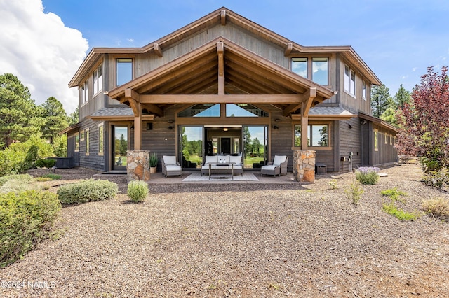 rear view of property featuring a patio area and an outdoor living space