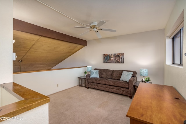 carpeted living room featuring a ceiling fan and lofted ceiling with beams