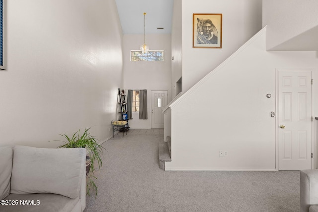 foyer with carpet and a towering ceiling