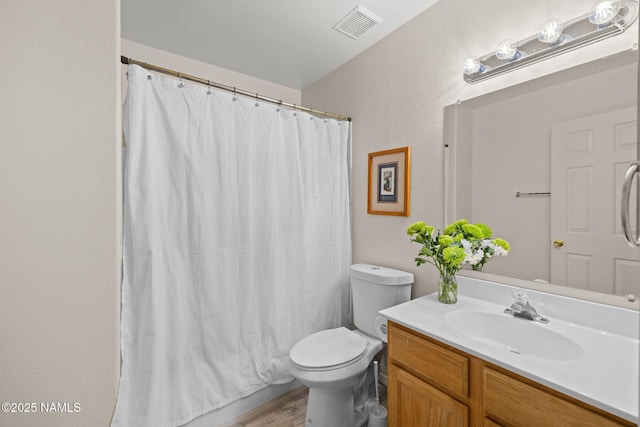 bathroom with hardwood / wood-style floors, toilet, a shower with shower curtain, and vanity