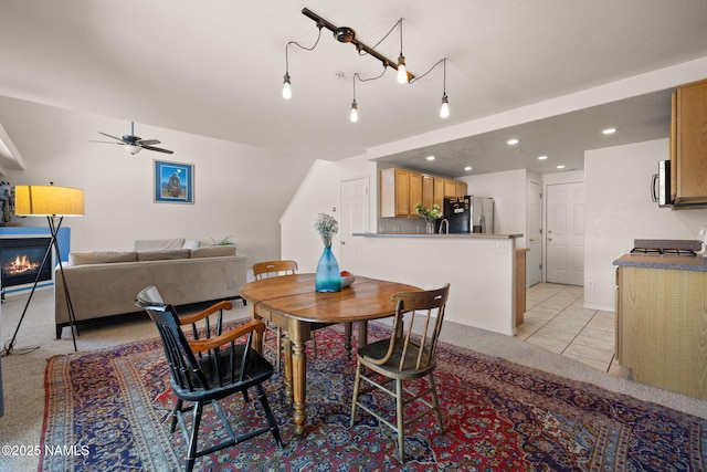 tiled dining space with ceiling fan