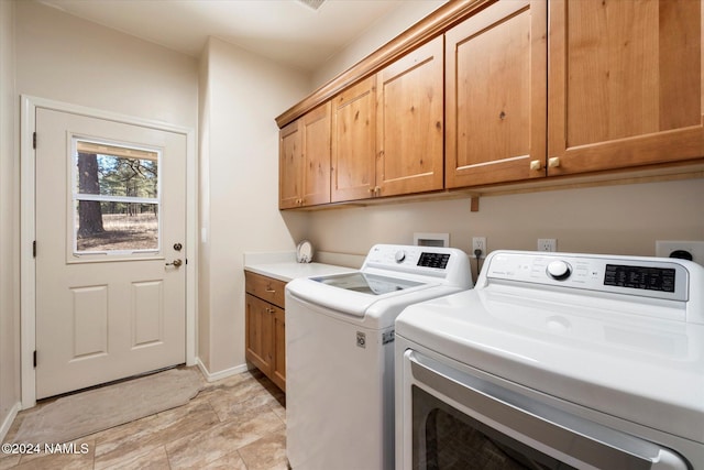 washroom with independent washer and dryer and cabinets