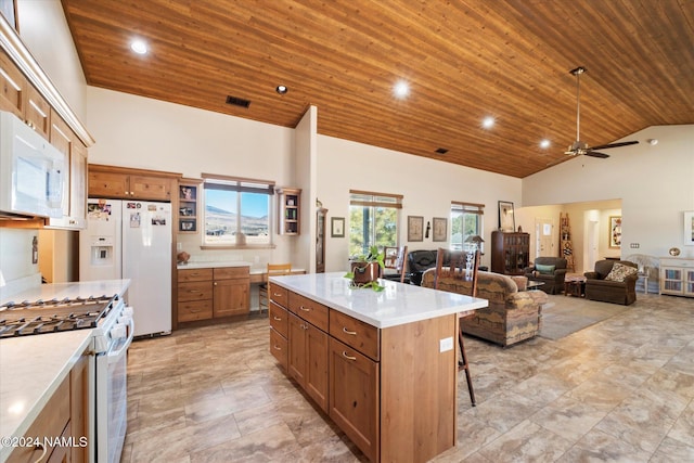 kitchen featuring white appliances, a center island, high vaulted ceiling, wooden ceiling, and a breakfast bar area