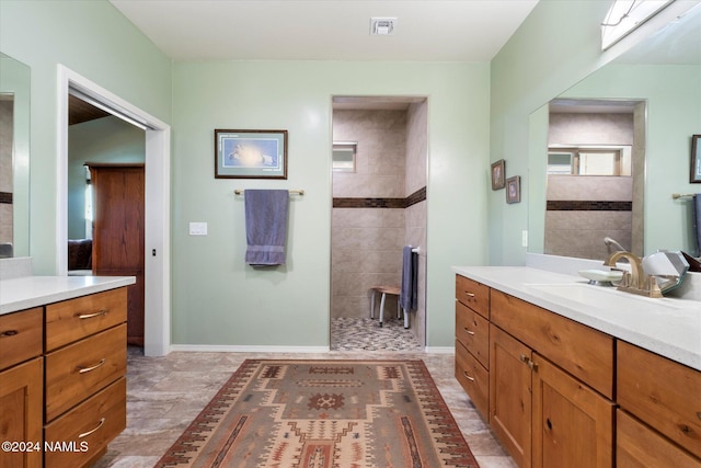 bathroom featuring vanity, a skylight, and tiled shower