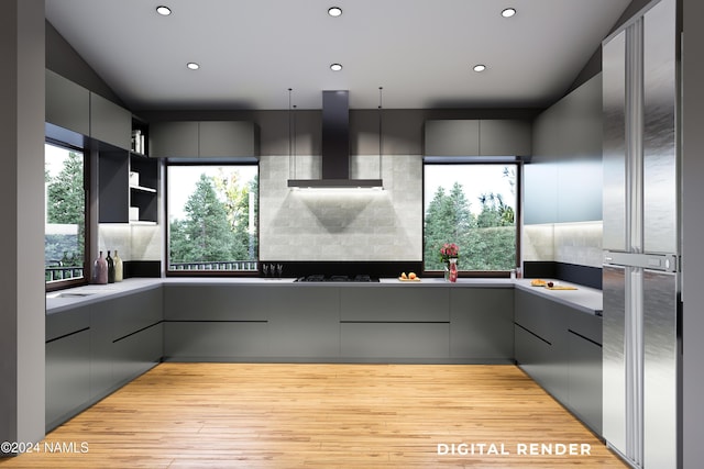 kitchen featuring wall chimney exhaust hood, modern cabinets, a wealth of natural light, and gray cabinetry