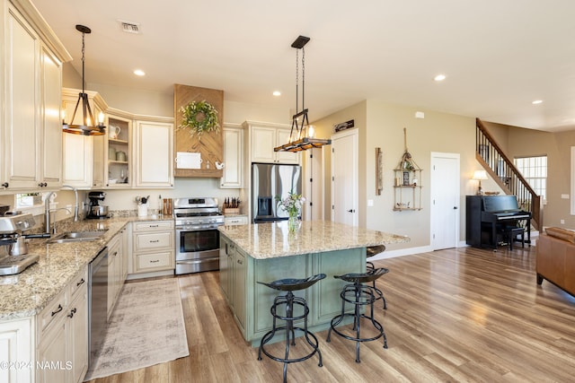10833 Sage Rd, Flagstaff, AZ 86004 - kitchen featuring light wood-style flooring, visible vents, a kitchen bar, appliances with stainless steel finishes, and a sink