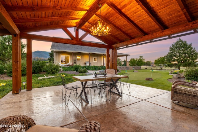 10833 Sage Rd, Flagstaff, AZ 86004 - patio terrace at dusk featuring a mountain view, outdoor dining space, and a gazebo