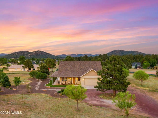 10833 Sage Rd, Flagstaff, AZ 86004 - view of front of home with driveway, a mountain view, an attached garage, and covered porch