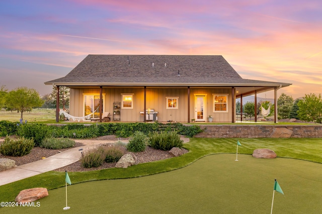 10833 Sage Rd, Flagstaff, AZ 86004 - back of house at dusk with a lawn, board and batten siding, and a shingled roof