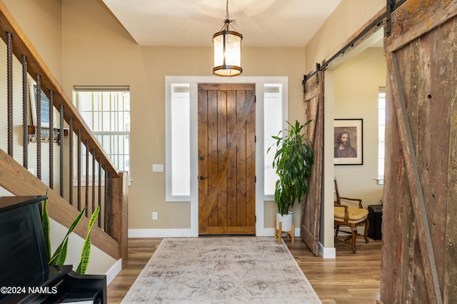 10833 Sage Rd, Flagstaff, AZ 86004 - foyer entrance featuring baseboards, a barn door, and wood finished floors