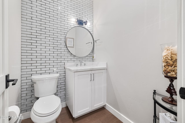 bathroom with hardwood / wood-style flooring, toilet, and vanity