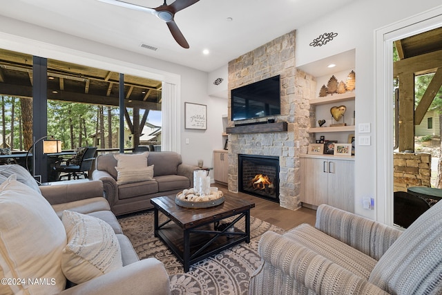 living room with built in shelves, plenty of natural light, dark hardwood / wood-style floors, and a fireplace