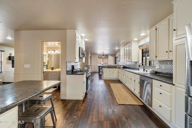 kitchen with white cabinetry, stainless steel appliances, dark hardwood / wood-style floors, and sink