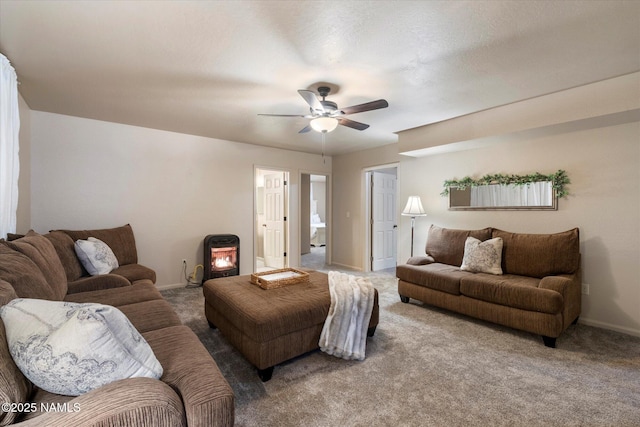 living room with carpet, ceiling fan, and a wood stove