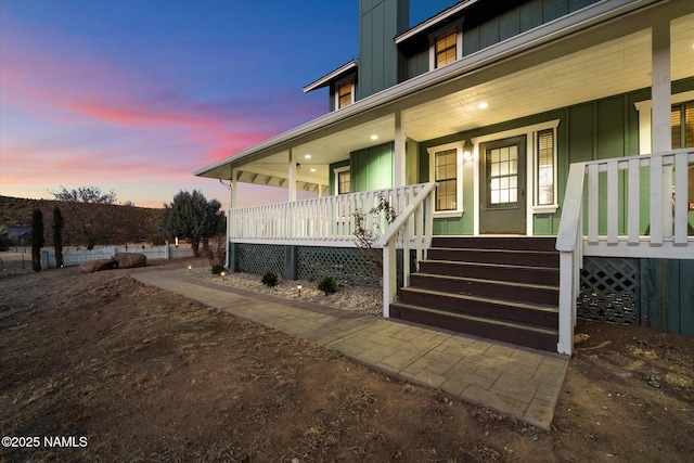 exterior entry at dusk with covered porch