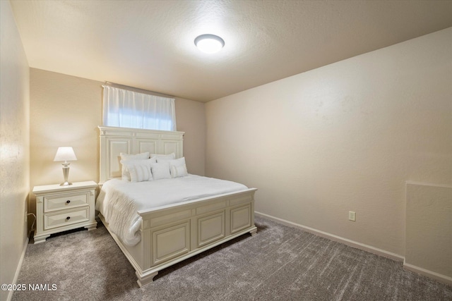 bedroom with dark colored carpet and a textured ceiling