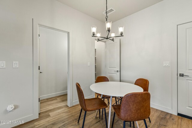 12220 Curtis Ct, Bellemont, AZ 86015 - dining room featuring visible vents, baseboards, a chandelier, and light wood-style floors