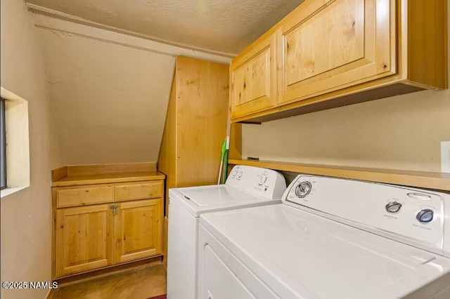 laundry area featuring washer and dryer, a textured ceiling, and cabinet space