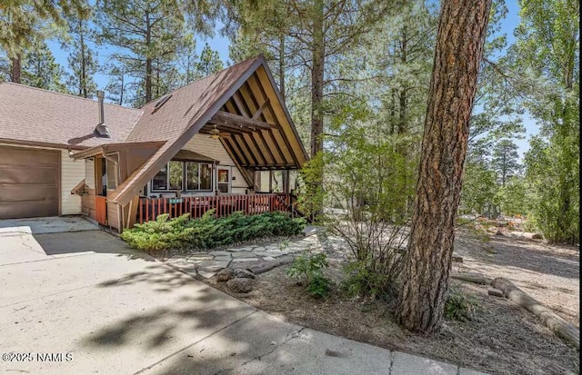 exterior space featuring a shingled roof, a garage, and concrete driveway