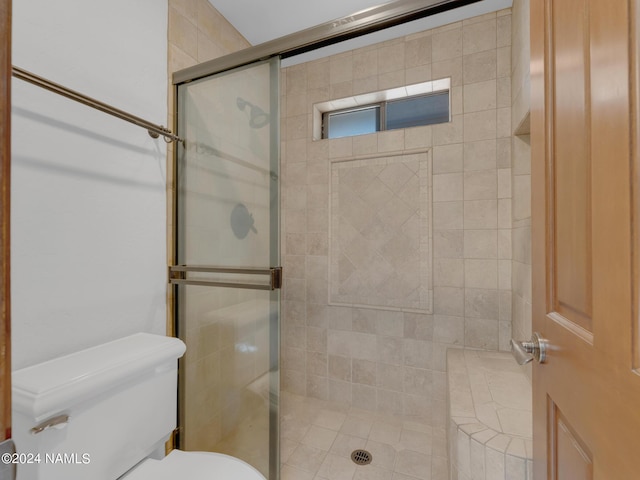 bathroom with toilet and a shower with shower door