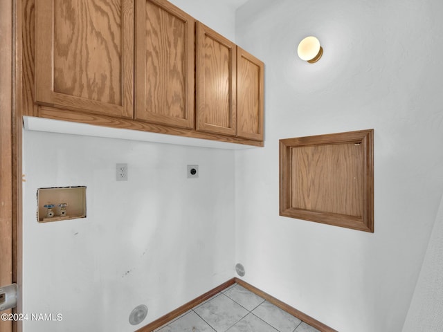 laundry area with hookup for a washing machine, hookup for an electric dryer, light tile patterned floors, and cabinets