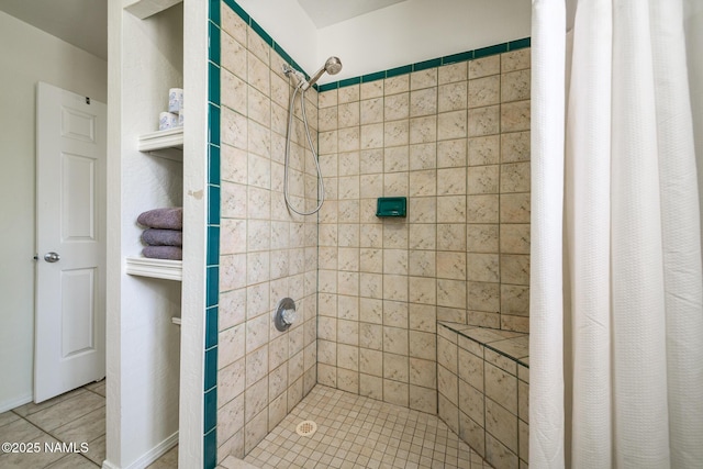 full bath featuring a tile shower and tile patterned flooring