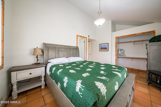bedroom featuring a wood stove, light tile patterned floors, a closet, and vaulted ceiling