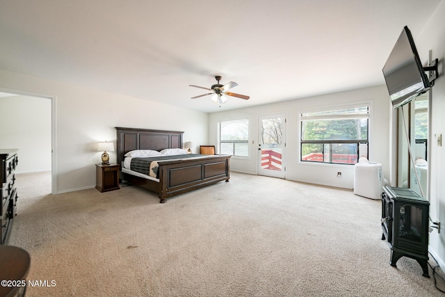 bedroom featuring baseboards, access to outside, light colored carpet, and a ceiling fan