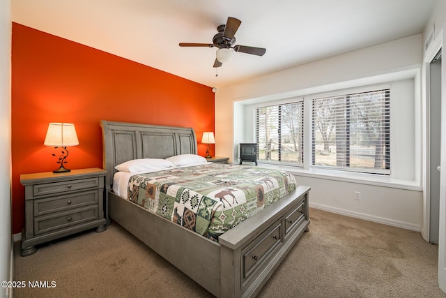 bedroom with light colored carpet, baseboards, and ceiling fan