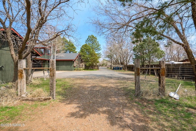 view of yard with driveway and fence