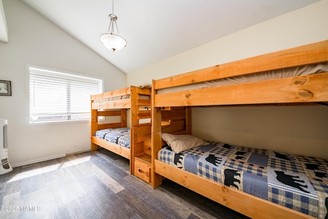 bedroom featuring wood finished floors, baseboards, and vaulted ceiling