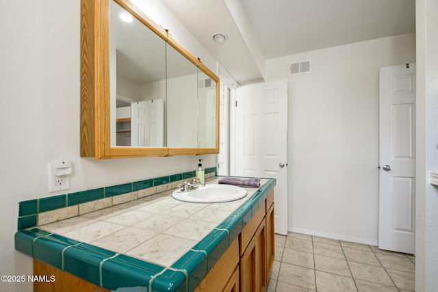 bathroom featuring tile patterned flooring, vanity, visible vents, and baseboards