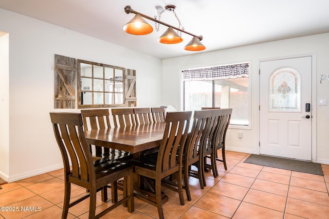 dining area featuring light tile patterned floors and baseboards