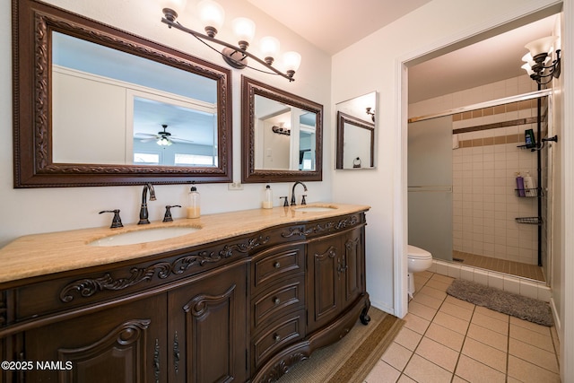bathroom featuring toilet, tile patterned floors, a sink, and a stall shower