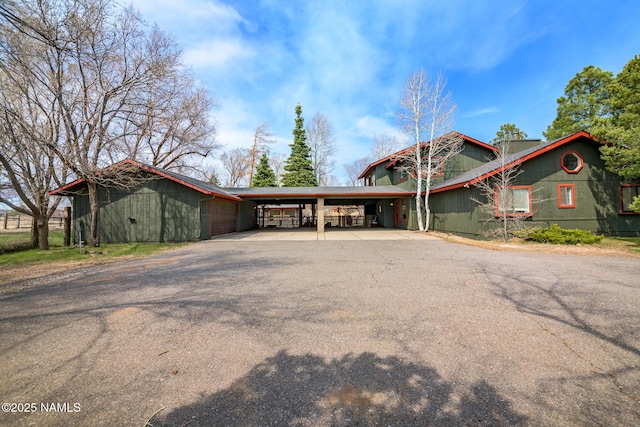 view of front facade with a carport and aphalt driveway