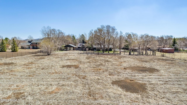 view of yard featuring a rural view and fence