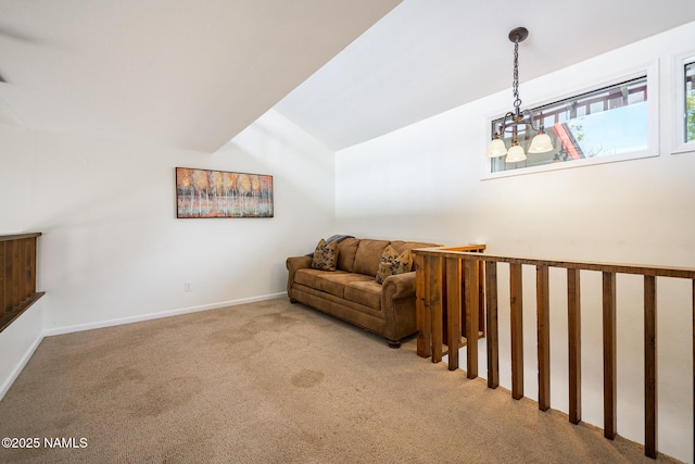 living area with carpet floors, baseboards, and vaulted ceiling