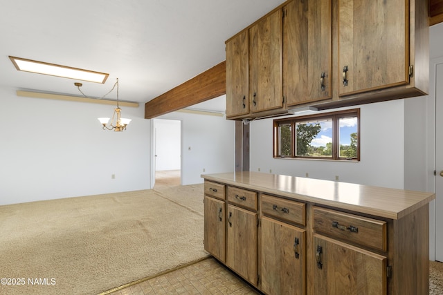 5920 Wildflower Rd, Flagstaff, AZ 86004 - kitchen featuring light countertops, a chandelier, beamed ceiling, and light carpet