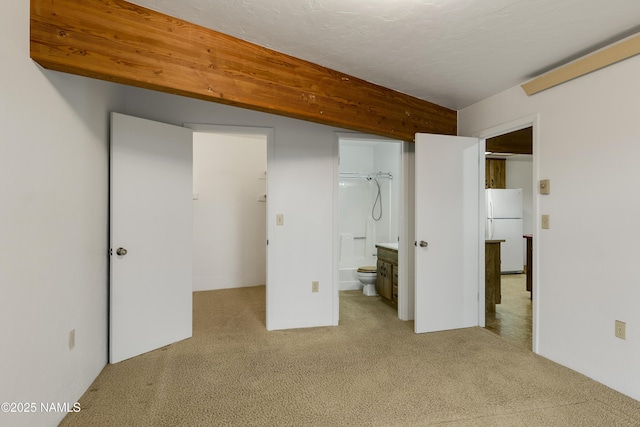 5920 Wildflower Rd, Flagstaff, AZ 86004 - unfurnished bedroom featuring ensuite bathroom, a walk in closet, carpet, and freestanding refrigerator