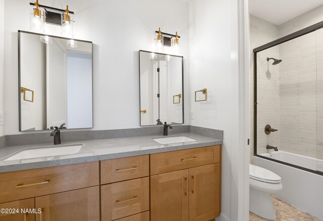 full bathroom featuring combined bath / shower with glass door, toilet, and vanity