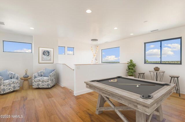 unfurnished living room with ceiling fan, hardwood / wood-style flooring, a towering ceiling, and a stone fireplace