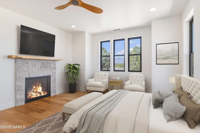 bedroom featuring a fireplace, recessed lighting, wood finished floors, and visible vents