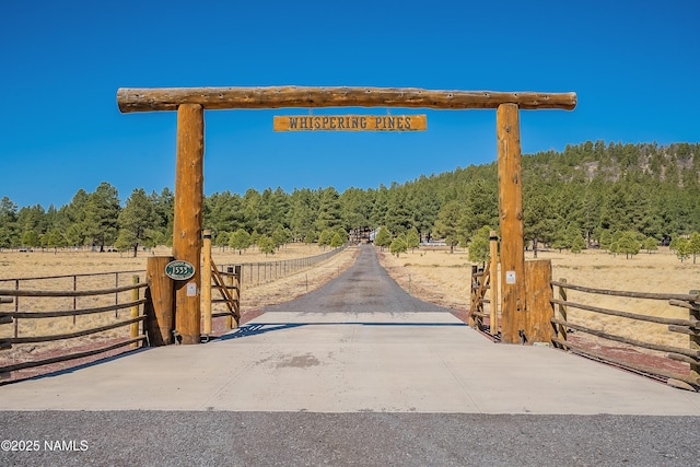 1533 S Minstrel Ln, Williams, AZ 86046 - view of concrete surface featuring a view of trees, a gate, and a gated entry