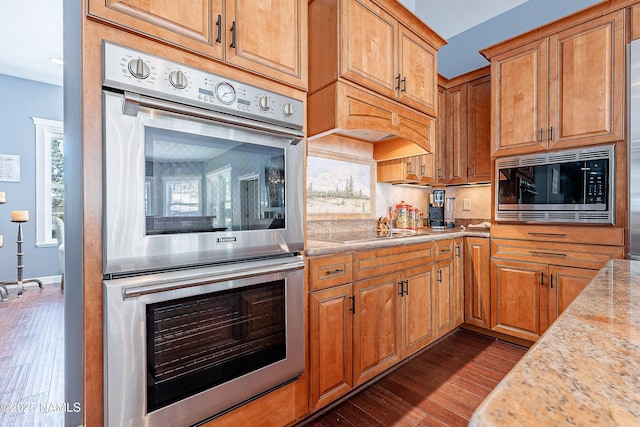1533 S Minstrel Ln, Williams, AZ 86046 - kitchen featuring appliances with stainless steel finishes, dark wood-type flooring, tasteful backsplash, and brown cabinets