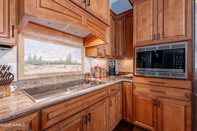 1533 S Minstrel Ln, Williams, AZ 86046 - kitchen featuring stainless steel microwave, black electric stovetop, and brown cabinets