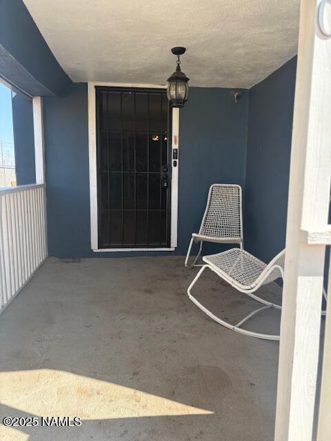 property entrance featuring a balcony and stucco siding