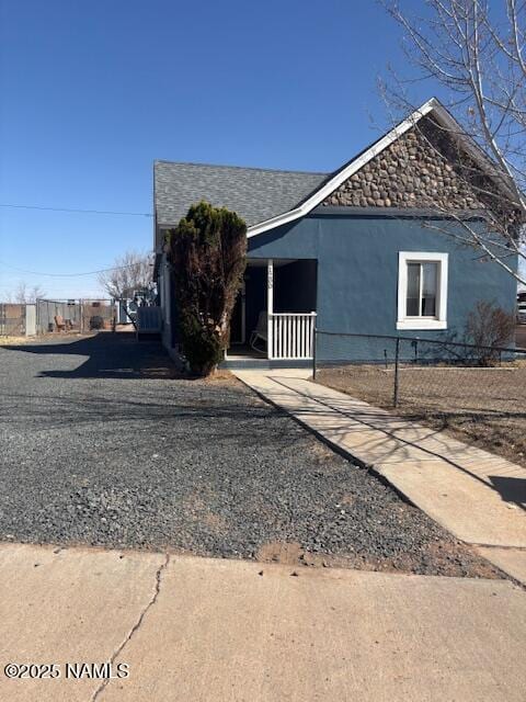 view of front of house featuring fence and roof with shingles